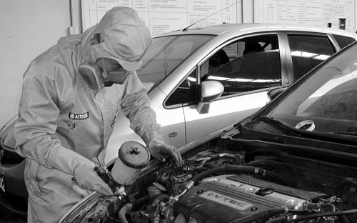 使用防毒面具正在做汽車噴漆保養