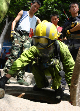 消防員戴防毒面具下井救人