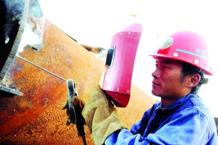 戴焊接面罩工作的電焊工人