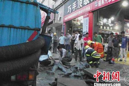 消防員正在對遇險的化糞池作業人員進行施工救援