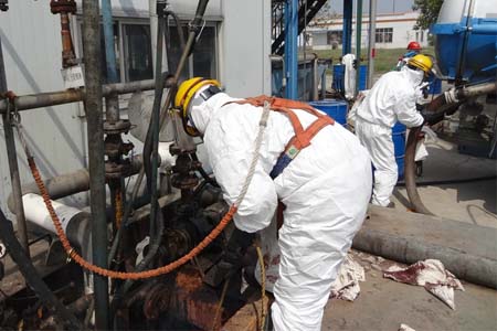 工人穿戴輕型防化服清理污水池