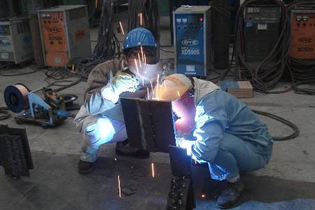 正在進(jìn)行電焊作業(yè)的工人戴著焊接面屏
