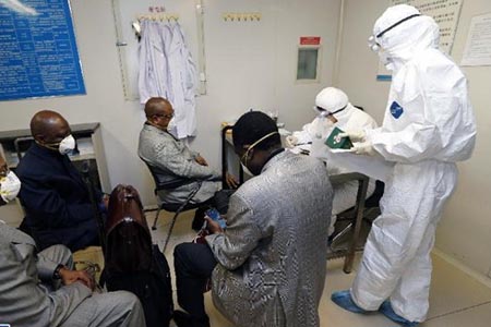 醫護人員穿戴埃博拉防護服、護目鏡及手套處理患者